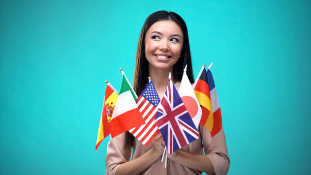 異なる国旗を掲げる笑顔のアジア人女性、国際協力 - portuguese culture women ethnic smiling ストックフォトと画像