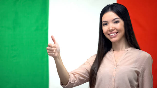 Happy female showing thumbs-up against Italian flag background, migration Happy female showing thumbs-up against Italian flag background, migration Study Abroad Countries stock pictures, royalty-free photos & images