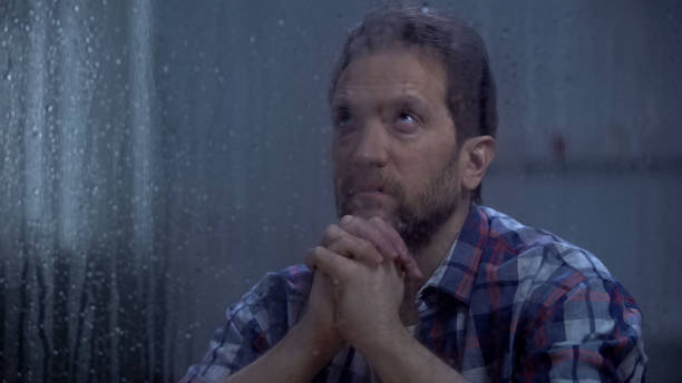 istock Hopeless male praying God behind rainy window, asking for help and forgiveness 1169983388
