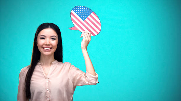 istock Smiling girl holding USA flag speech bubble, learning language, travel ideas 1169983504