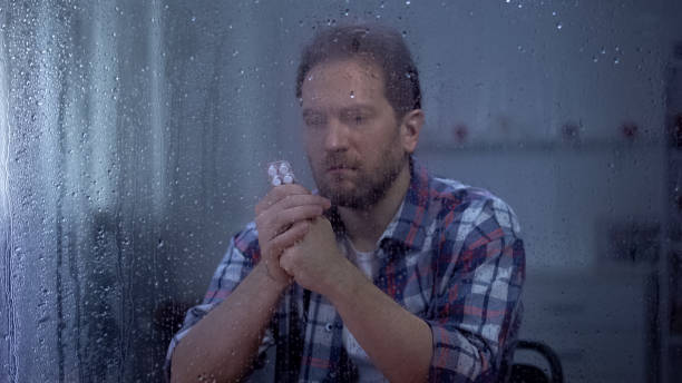 istock Ill man reading pills dosage form behind rainy window worrying about side effect 1169984272
