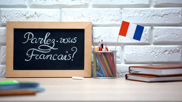 Do you speak French written on board, France flag standing in box, language stock photo