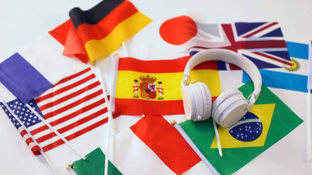 bandiere di diversi paesi e cuffie sdraiate sul tavolo, concetto di lezione audio - spanish culture audio foto e immagini stock