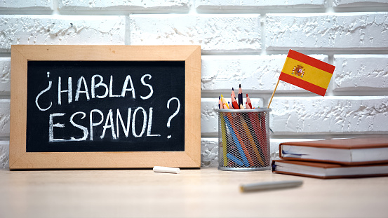 ¿Hablas español escrito a bordo, bandera internacional en caja, idioma photo