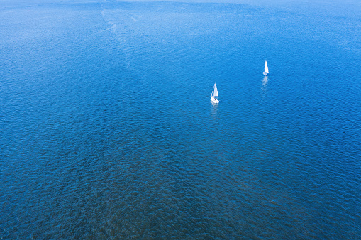 Two small sports yachts on the high seas aerial view. Deep blue seascape at sunny day