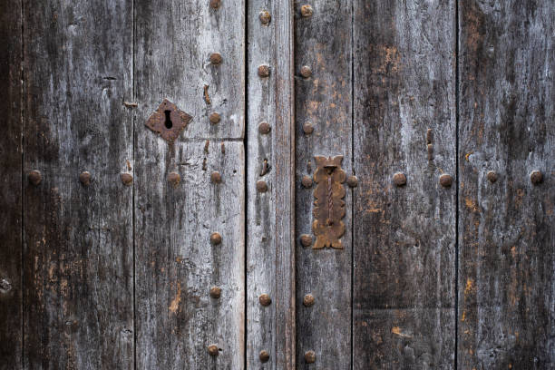 istock Old grey wooden door with forged rivets. 1169989512