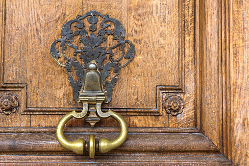 Beautiful and old door handle in a residential house in Paris, France.