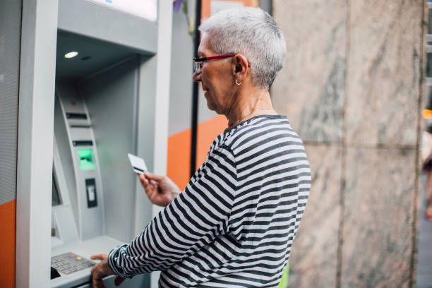 istock Senior woman using an ATM 1169998863