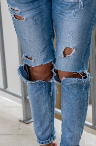 istock women's legs dressed in jeans with holes 1169999932