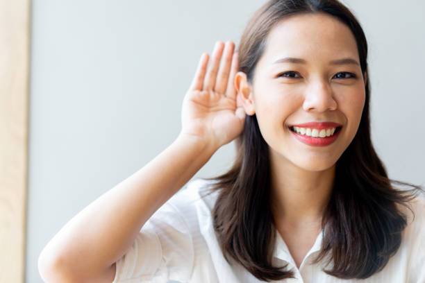 close up young beautiful asian doctor woman smiling with happiness and using hand behind ear to trying listening for deafness concept close up young beautiful asian doctor woman smiling with happiness and using hand behind ear to trying listening for deafness concept american sign language photos stock pictures, royalty-free photos & images