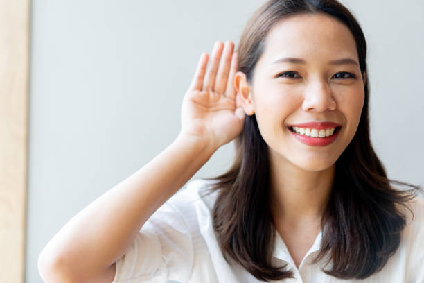 close up young beautiful asian doctor woman smiling with happiness and using hand behind ear to trying listening for deafness concept close up young beautiful asian doctor woman smiling with happiness and using hand behind ear to trying listening for deafness concept n11 stock pictures, royalty-free photos & images