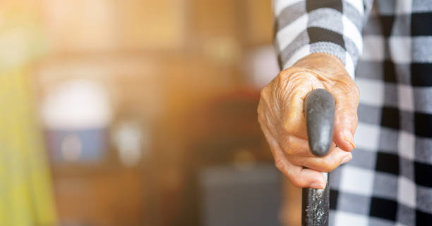 自宅に立つのを助ける歩行サトネを抱くクローズアップシニア女性手、高齢者のライフスタイルコンセプト - human hand aging process senior adult cane ストックフォトと画像