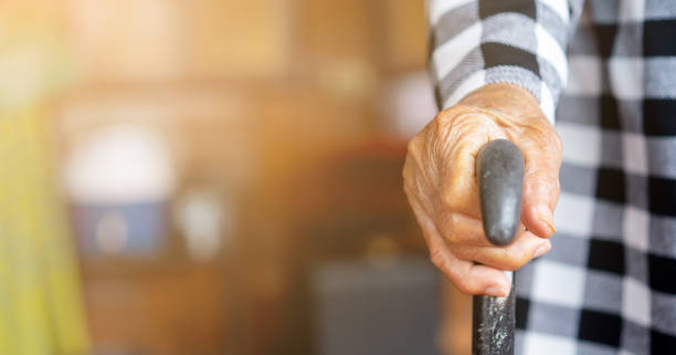 closeup senior woman hand holding walking cane to help stand at home , lifestyle of aging people concept closeup senior woman hand holding walking cane to help stand at home , lifestyle of aging people concept one senior woman only stock pictures, royalty-free photos & images