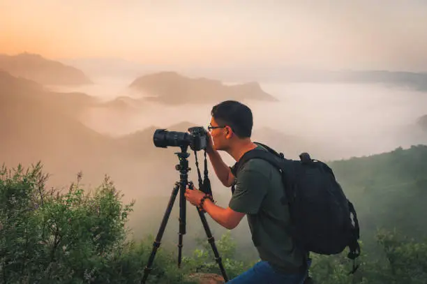 Professional photographer takes photos with camera on tripod