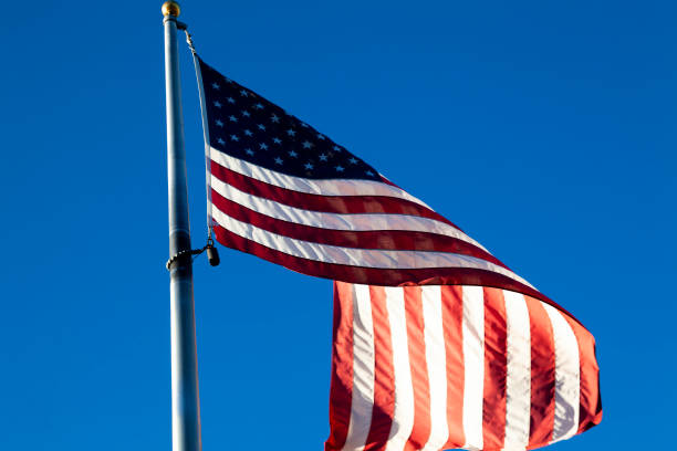 istock United States Flag On Flag Pole From Below Blue Sky 1170014434
