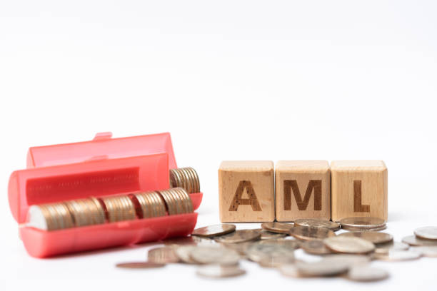 Money laundering concept, wooden word block "AML" on plie of coins. stock photo