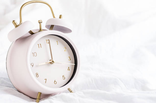 istock Retro white alarm clock on the bed 1170018591