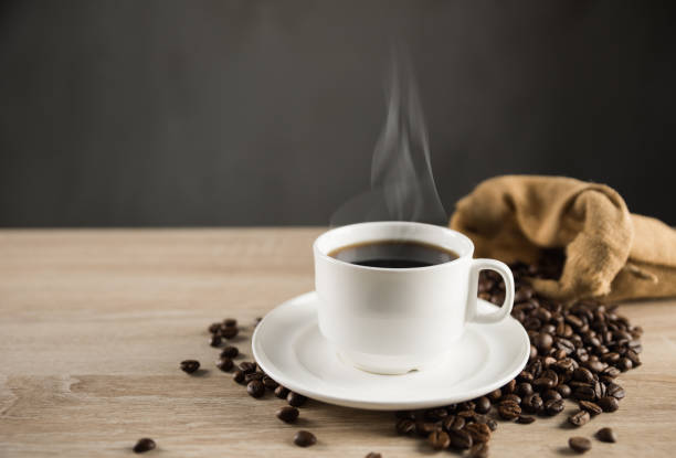 istock Hot coffee cup and beans on wood background 1170024526