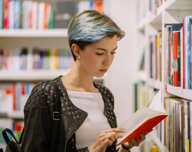 Photo of young subculture punk woman in library