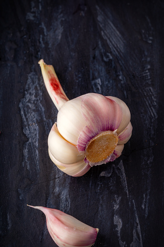 top down view of garlic, garlic peel, on a black slate.