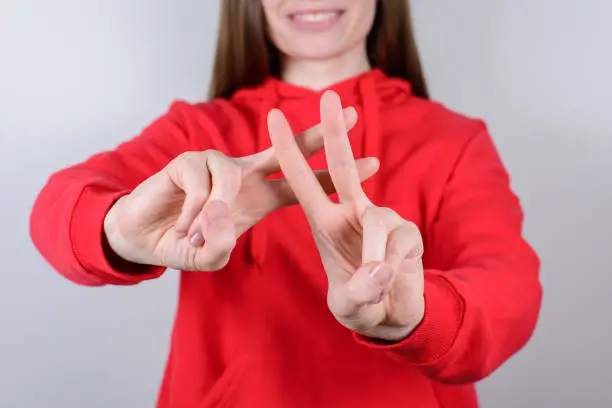 Photo of Cropped closeup photo portrait of positive charming pretty beautiful teen teenager human give make hashtag signal isolated gray background