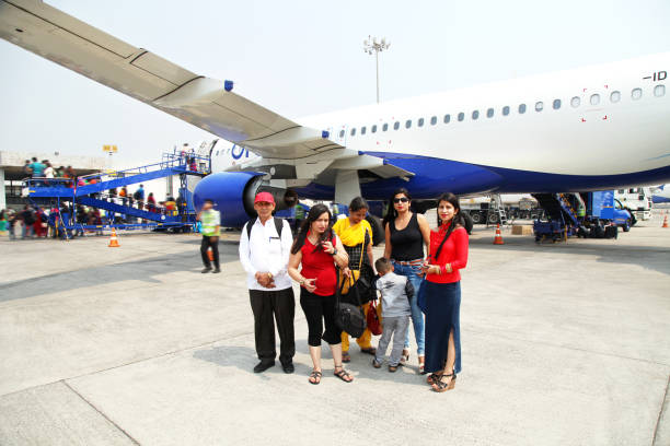 istock Family standing in front of passenger plane 1170042849