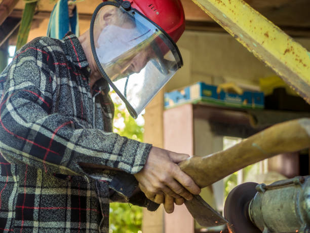 istock young man in protection mask sharpening an ax using a grinder 1170044294