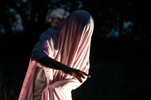 istock unrecognizable maniac murder in white blank sheet in night forest f 1170050376