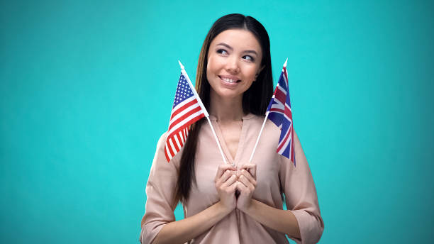 istock Curious girl holding Great Britain and USA flags, language difference, education 1170061138