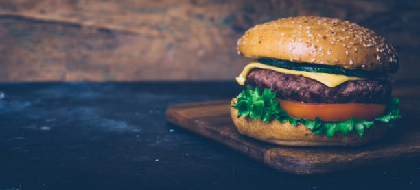 istock Home made Burger (cheeseburger) with beef on a wooden background. Classic home made Burger. Close up, copy space. 1170065432