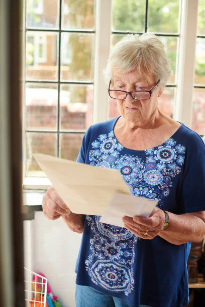 нежелательная почта для старшей женщины - mailbox mail junk mail opening стоковые фото и изображения