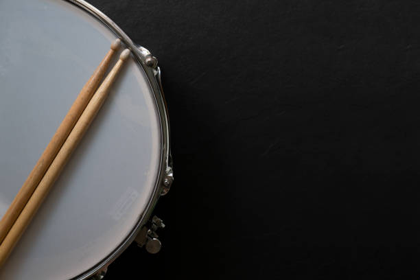 istock Drum stick and drum on black table background, top view, music concept 1170066415