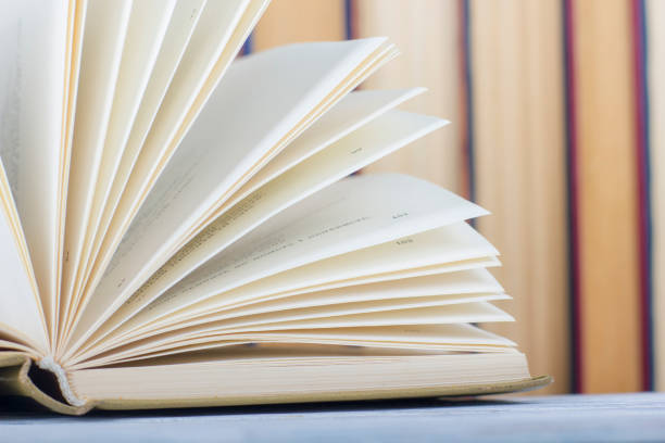 istock Open book, hardback books on wooden table. Back to school. Copy space 1170068824