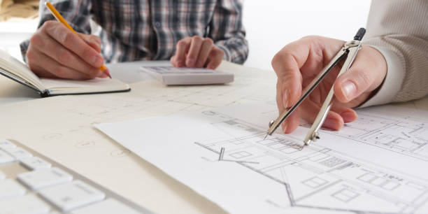 istock Architects working on blueprint, real estate project. Architect workplace - architectural project, blueprints, ruler, calculator, laptop and divider compass. Construction concept. Engineering tools. 1170068915