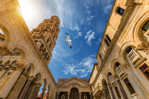 el peristo del palacio de diocleciano frente al campanario de la catedral de san domnius en split, croacia. palacio de diocleciano patrimonio de la humanidad de la unesco en split, dalmacia, croacia. - religion christianity bell tower catholicism fotografías e imágenes de stock