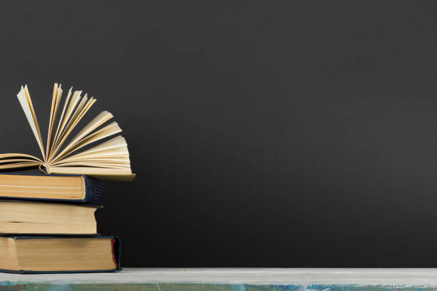 istock Open book, hardback books on wooden table. Back to school. Copy space 1170070660