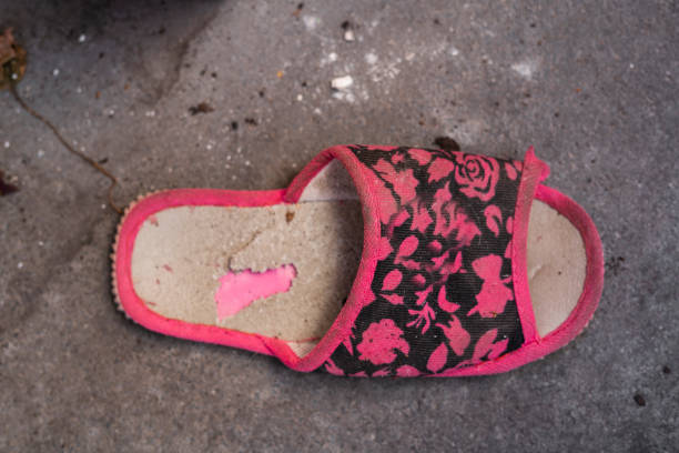 A pair of pink sport shoes laying on the street at the scene of an accident
