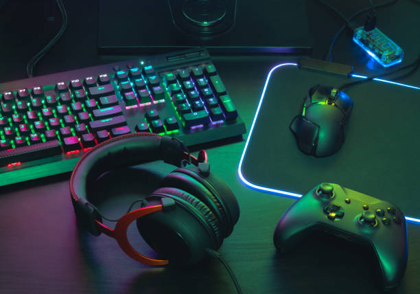 gamer work space concept, top view a gaming gear, mouse, keyboard, joystick, headset, mobile joystick, in ear headphone and mouse pad on black table background. gamer work space concept, top view a gaming gear, mouse, keyboard, joystick, headset, mobile joystick, in ear headphone and mouse pad on black table background. computer game control stock pictures, royalty-free photos & images