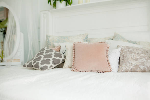 istock Scandinavian style white bedroom. Four pillows are on the bed. Modern interior 1170075071