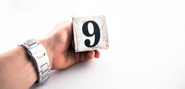 istock A hand holding digit number 9 (nine) on white background 1170075299