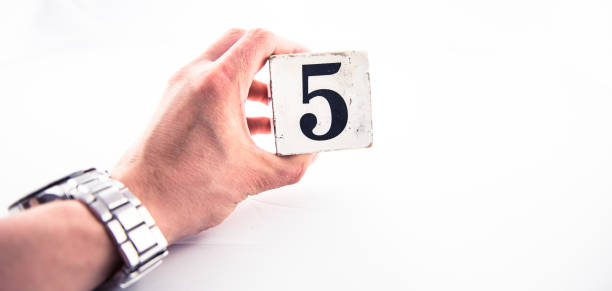 istock A hand holding digit number 5 (five) on white background 1170075300