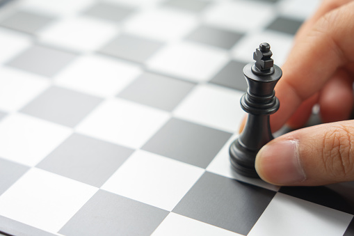 Businessman holding a King Chess is placed on a chessboard.using as background business concept and Strategy concept with copy space for your text or design.
