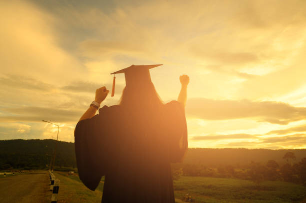 istock Sillhouette Graduation Female Stand for joy at sunset 1170079547