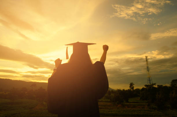istock Sillhouette Graduation Female Stand for joy at sunset 1170079563