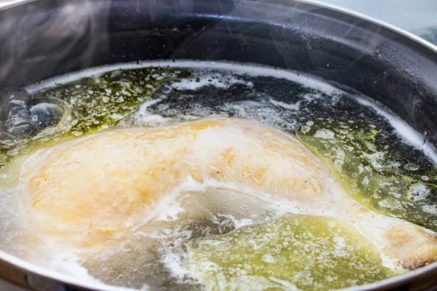 boiled chicken in a pot broth close-up with blurred background and front