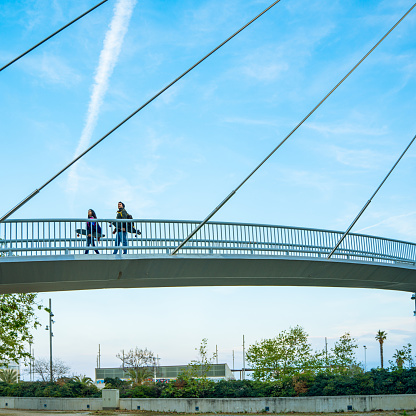 Two skaters with their longboards walking on an elevated walkway