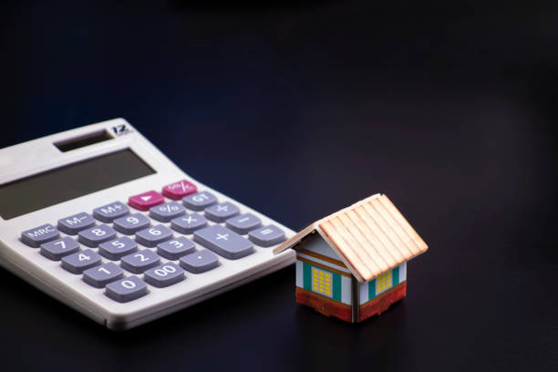 istock Small houses and calculators in a black background 1170082572