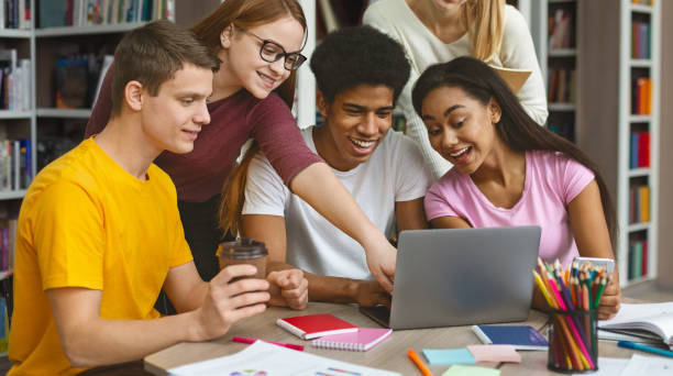 istock Group of intelligent students discussing the project in library 1170086091