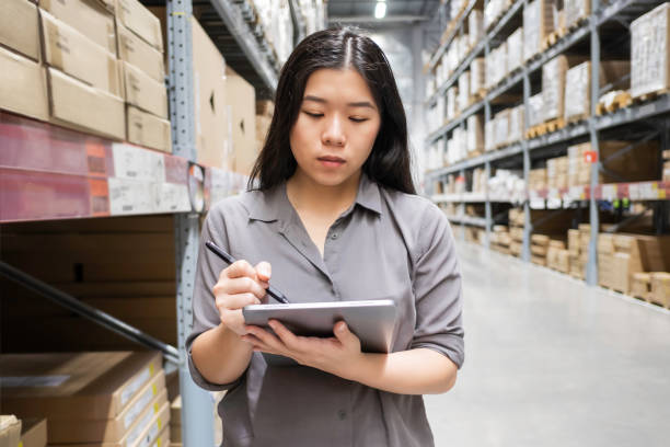 istock Beautiful young Asian woman auditor or trainee staff work stocktaking with computer tablet at warehouse store, Asian working business woman concept 1170088288