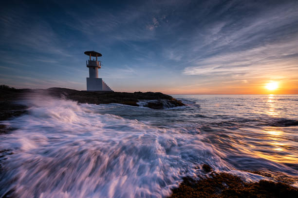 istock Lighthouse at sunset on the beach 1170088339